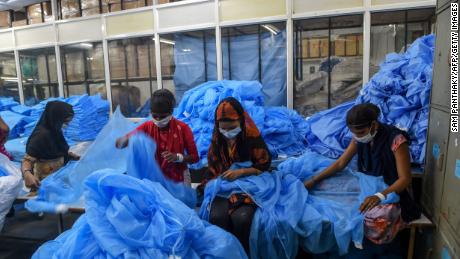 Workers prepare protective clothing and gear at a facility of personal protective equipments manufacturer Nikshe Multiproducts on the outskirts of Ahmedabad on April 2, 2020.