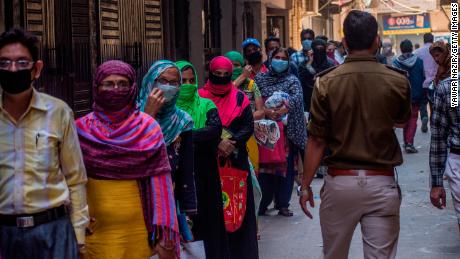 Indians wait to receive rations during the nationwide lockdown on April 2, 2020 in New Delhi.