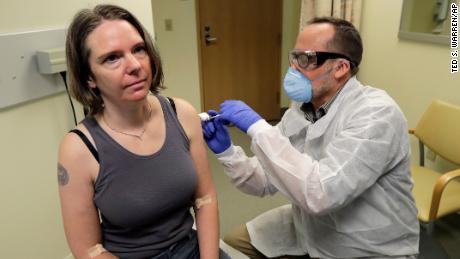 A pharmacist gives Jennifer Haller, left, the first shot in the first-stage safety study clinical trial of a potential vaccine for COVID-19, the disease caused by the new coronavirus, Monday, March 16, 2020, at the Kaiser Permanente Washington Health Research Institute in Seattle. (Photo by Ted S. Warren/Associated Press)