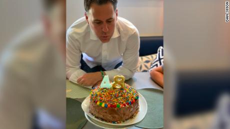 Simon blows out the candles on his birthday cake, homemade and delicious.