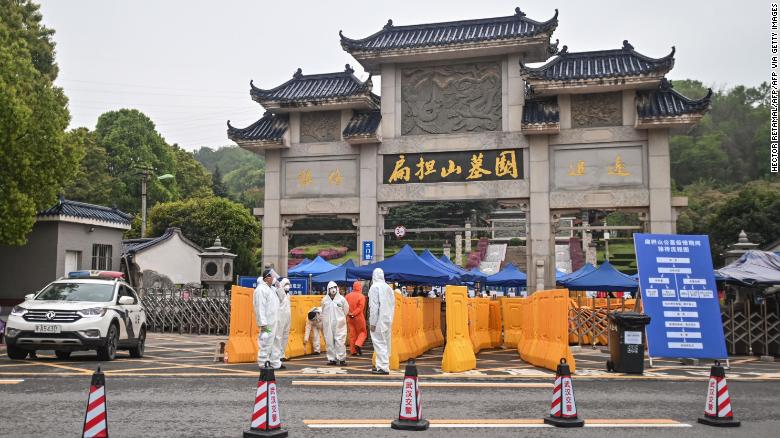 People wearing hazmat suits standing guard at the entrance to the Biandanshan cemetery in Wuhan on March 31.