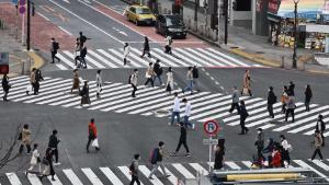 People cross an intersection usually filled with people in the Shibuya area in Tokyo on April 5, 2020. (Photo by CHARLY TRIBALLEAU / AFP) (Photo by CHARLY TRIBALLEAU/AFP via Getty Images)