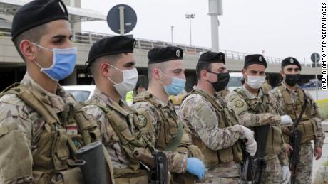 Lebanese soldiers, wearing protective equipment, stand guard at Beirut international airport on April 5, ahead of the arrival of returning nationals.