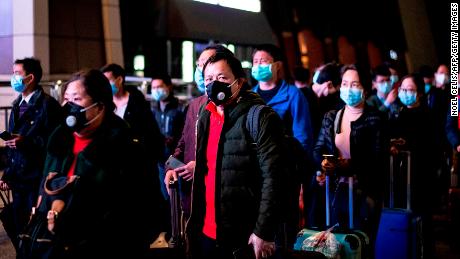 Passengers wear facemasks as they form a queue at the Wuhan Wuchang Railway Station in Wuhan, early on April 8, as they prepare to leave the city for the first time in more than ten weeks.