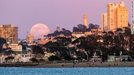 A full moon rises above the horizon in San Francisco, California on April 7, 2020. 