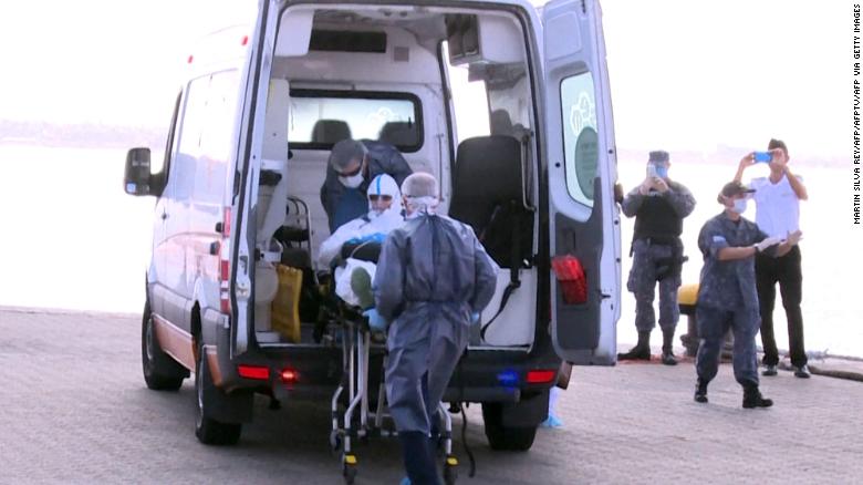 A 75-year-old Australian passenger suffering from pneumonia is seen being evacuated from the Greg Mortimer cruise liner to an ambulance in Montevideo on April 3, 2020.