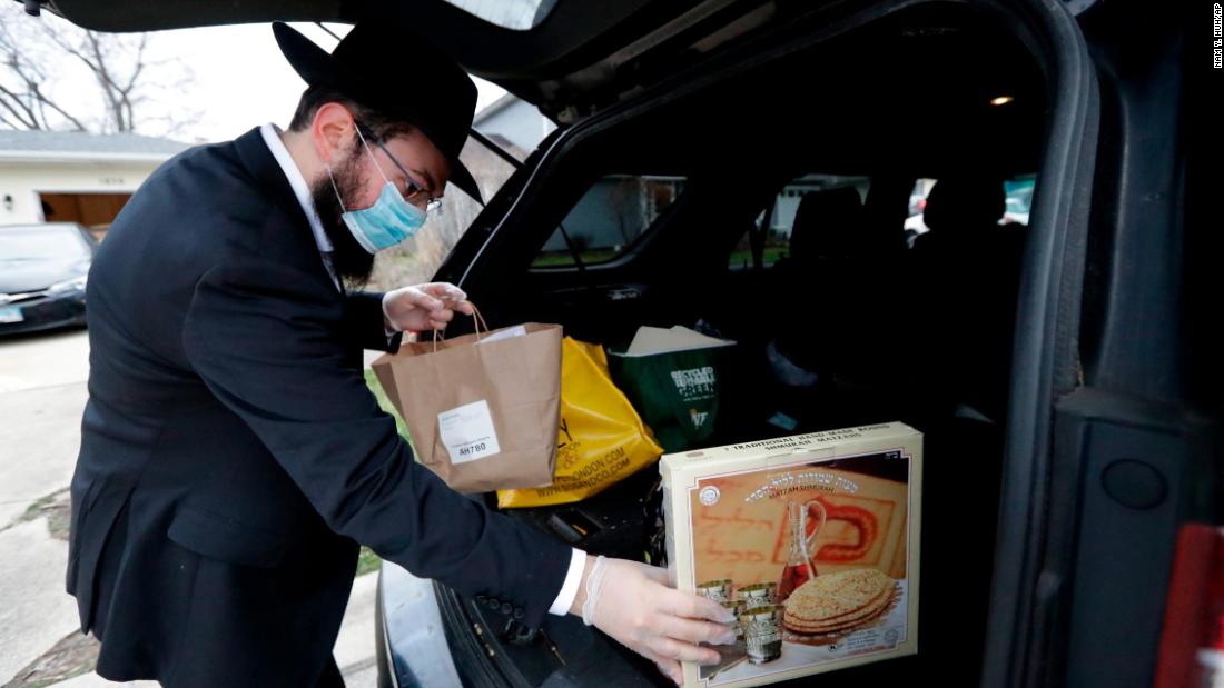 Rabbi Yaakov Kotlarsky places Passover Seder to-go packages into a car trunk in Arlington Heights, Illinois.