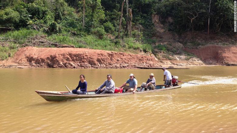 Paleontologists crossing the Rio Yurúa in Amazonian Perú, with the Santa Rosa fossil site in the background. [Credit: Dorien de Vries]
