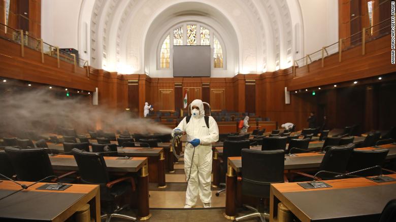 Sanitary workers disinfect the desks and chairs of the Lebanese Parliament on March 10.