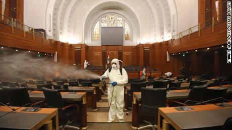 Sanitary workers disinfect the desks and chairs of the Lebanese Parliament on March 10.