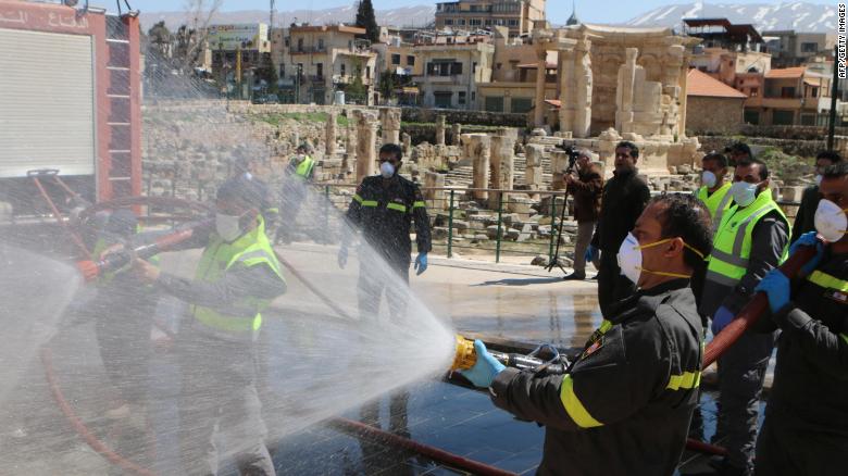 Members of the Lebanese civil defense forces spray disinfectant at Baalbek&#39;s Roman ruins on March 16.