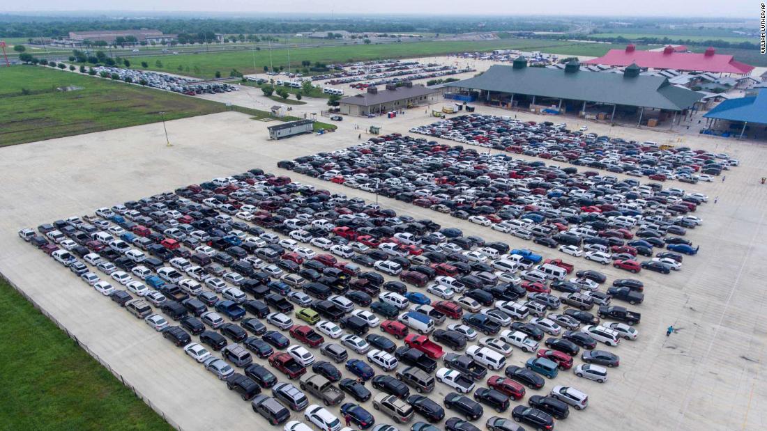 People wait in their cars for the San Antonio Food Bank to begin food distribution on April 9, 2020.