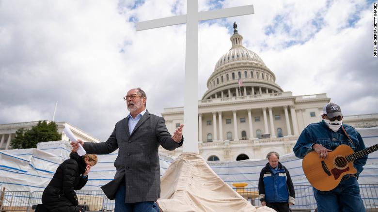 2020年4月10日、ワシントンDCで米国国会議事堂の敷地内でグッドフライデーサービスをライブストリーミングしているクリスチャンディフェンス連合のディレクター、パトリックマホニー牧師は祈りの中でひざまずきます。 