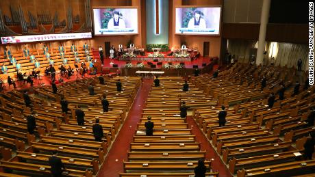 Mensen staan ver uit elkaar terwijl ze deelnemen aan een dienst in de Yoido Full Gospel Church in Seoul.