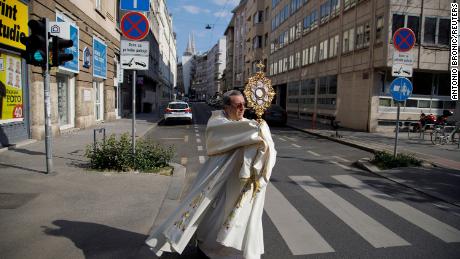 Priester Ivan Matic trägt ein Kreuz und segnet Gläubige, während er durch die Straßen von Zagreb, Kroatien, geht.