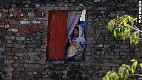 Una donna prega da casa sua durante un servizio speciale di Pasqua guidato da un pastore in un quartiere cristiano di Islamabad, Pakistan.