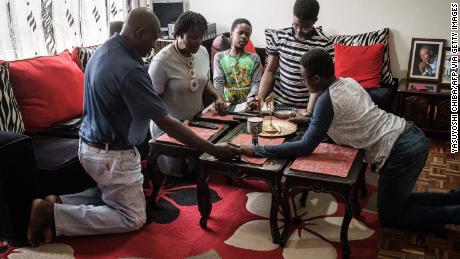 Una familia reza junta en su casa mientras sigue la transmisión en vivo de un servicio del Domingo de Pascua por televisión desde la Catedral de Todos los Santos en Nairobi, Kenia.