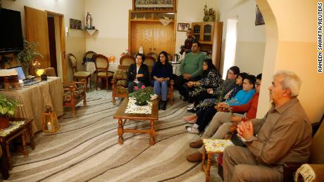 Leden van een orthodoxe Palestijnse christelijke familie kijken naar een live-uitzending van een kerkdienst in de buurt van Jenin, op de Westelijke Jordaanoever.