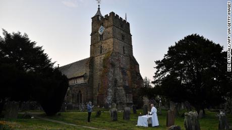 Der Vikar von Brenchley, Reverend Campbell Paget, hält einen Ostergottesdienst für ein einzelnes Mitglied seiner Gemeinde in der Morgendämmerung auf dem Kirchhof der All Saintsapos; Church in Brenchley, England.