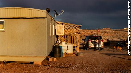 A Navajo woman carries wood to heat her rural mobile home during the coronavirus pandemic on March 27, 2020, in Cameron, Arizona. 