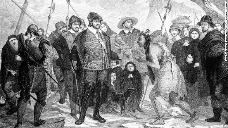 An illustration of Myles Standish and Pilgrims greeting a Native American at Plymouth Rock in 1620.