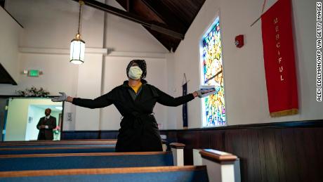 Uma mulher adora durante um culto na Igreja Baptista da Amizade em Baltimore.