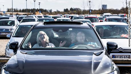 Personen singen Hymnen in ihren Autos auf einem Parkplatz am Flughafen Aalborg in Dänemark.