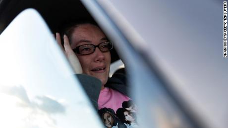 Breanna Archuletta essuie ses larmes alors qu'elle est assise dans sa voiture pendant un service en voiture organisé par les Delta Ministries à Delta, Colorado.