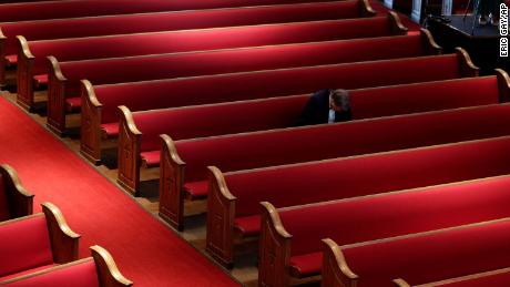 Een man zit alleen terwijl hij een paasdienst bijwoont in de Trinity Baptist Church in San Antonio, Texas.