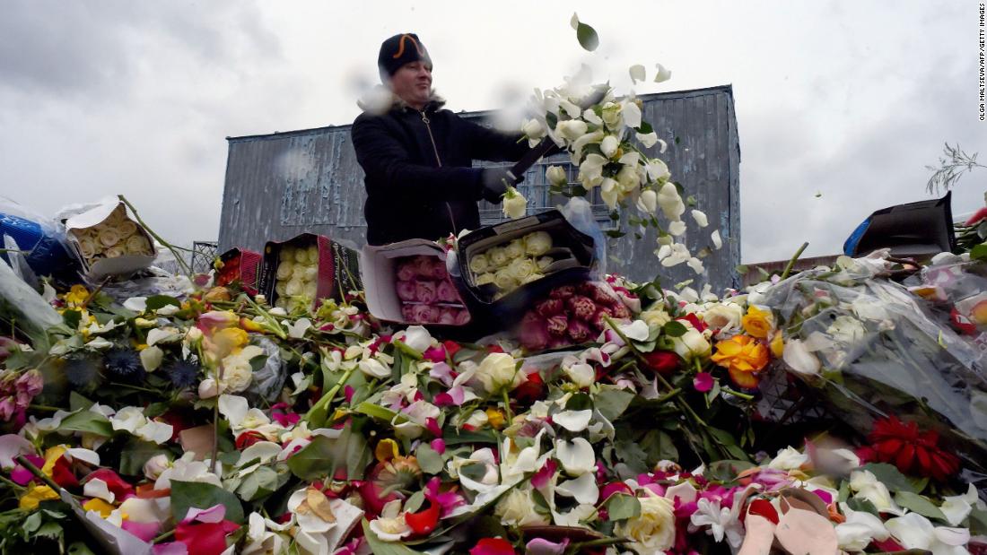 A flower shop employee destroys unsold flowers in St. Petersburg, Russia, on April 13, 2020.