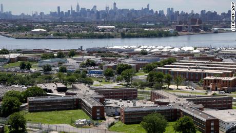 FILE - This June 20, 2014 file photo shows the Rikers Island jail complex in New York with the Manhattan skyline in the background. New York City lawmakers are considering a plan to close the notorious Rikers Island jail complex and replace it with four smaller jails. The City Council is set to vote Thursday, Oct. 17, 2019 on a plan to build the jails that would replace Rikers. (AP Photo/Seth Wenig, File)