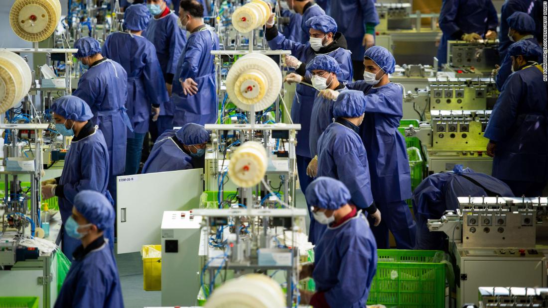 Workers produce protective face masks at a new factory near Tehran, Iran, on April 14, 2020.