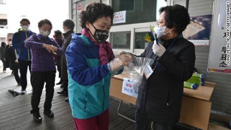A South Korean woman wears plastic gloves and a mask as she prepares to cast her ballot during April&#39;s election. 