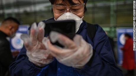 A passenger uses a smartphone while scanning a Wuhan city health QR code before entering Tianhe Airport in Wuhan on April 11.