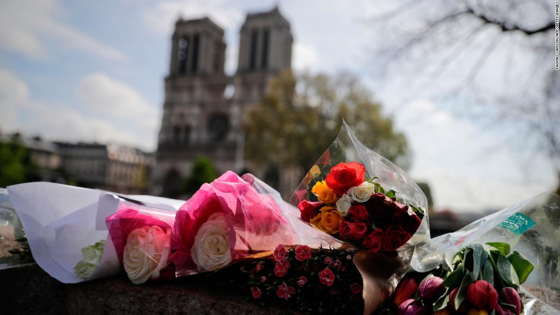 Flowers are laid on a bridge in front of Notre Dame on April 17, 2019.