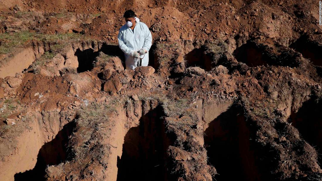 A cemetery worker pauses while digging graves at the San Vicente cemetery in Cordoba, Argentina.