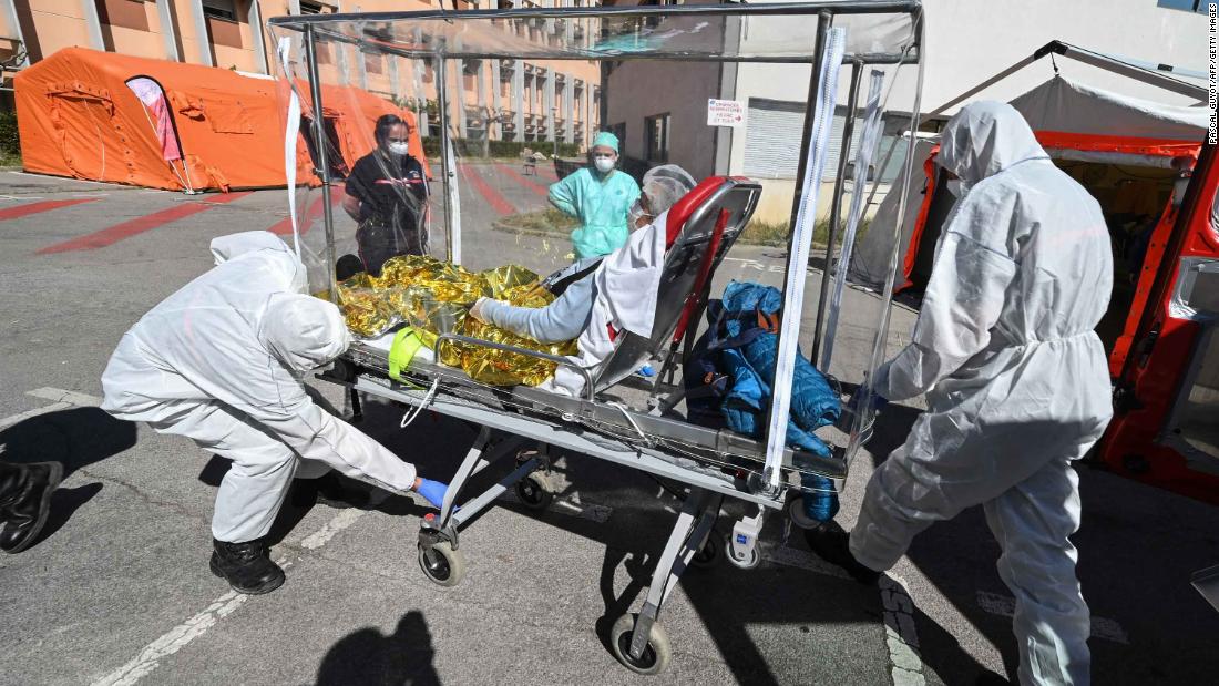 Firefighters transfer a patient from an ambulance in Montpelier, France, on April 14, 2020.