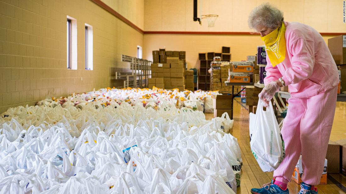 Volunteer Maria Cunningham sorts through bags of food before distributing them at a church in Des Moines, Iowa, in April.