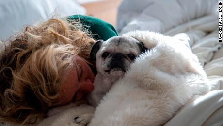 Laid very low by the coronavirus, Baldwin naps with her dog Pugsley.