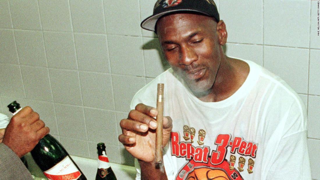 Jordan enjoys a cigar in the locker room after the Bulls finished off their second &quot;three-peat&quot; of the decade.