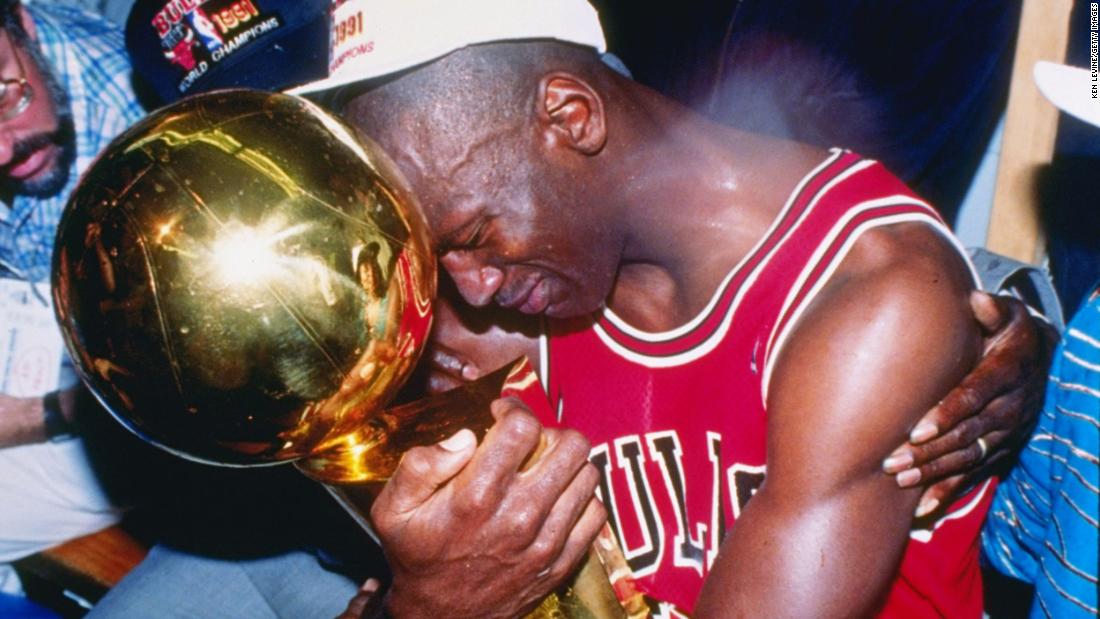 An emotional Jordan embraces the Larry O&#39;Brien Championship Trophy after the Bulls defeated the Lakers to win his first NBA title.