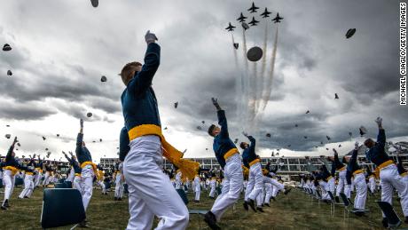 COLORADO SPRINGS, CO - APRIL 18: Spaced eight feet apart, United States Air Force Academy cadets celebrate their graduation as a team of F-16 Air Force Thunderbirds fly over the academy on April 18, 2020 in Colorado Springs, Colorado. After senior cadets spent more than a month on lockdown in the Air Force Academy&#39;s dorms due to the coronavirus pandemic, Saturday&#39;s graduation, which was moved up by six weeks, marks the first time a military academy is graduating a class early since WWII. (Photo by Michael Ciaglo/Getty Images)