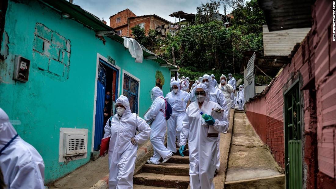 Mayor&#39;s office workers wear protective suits as they conduct a census in a Bogota, Colombia, neighborhood on April 19, 2020. They were trying to find out how many families needed to be provided with food.