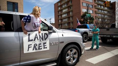 Health care workers stand in the street in counter-protest to hundreds of people who gathered at the State Capitol to demand the stay-at-home order be lifted in Denver, Colorado, U.S. April 19, 2020. REUTERS/Alyson McClaran MANDATORY CREDIT. NO RESALES. NO ARCHIVES     TPX IMAGES OF THE DAY