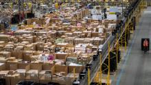 Workers prepare customer orders for dispatch as they work around goods stored inside an Amazon.co.uk fulfillment centre in Peterborough, central England, on November 15, 2017. - Shops could be seeing the effect of consumers postponing purchases until "Black Friday" on November 24, 2017, a day of sales in the United States that has become increasingly popular in Britain. (Photo by CHRIS J RATCLIFFE / AFP)        (Photo credit should read CHRIS J RATCLIFFE/AFP via Getty Images)