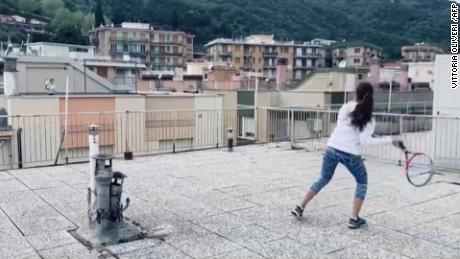 Social distancing leads two people to play rooftop tennis
