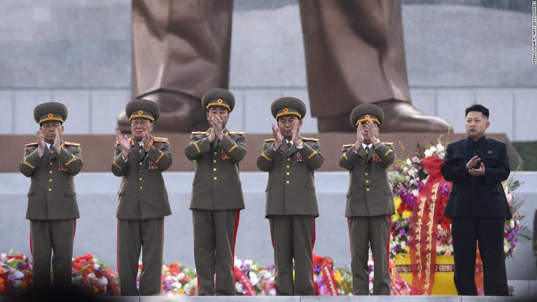 Kim claps as statues of his father and grandfather are unveiled in Pyongyang in April 2012.