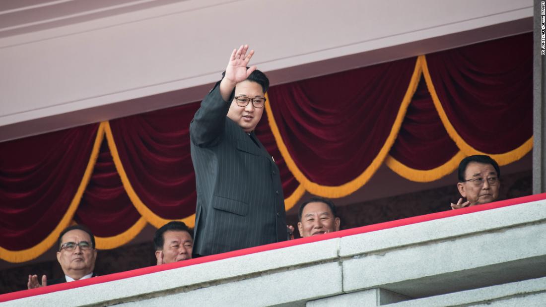 Kim waves as he walks past top-ranking party officials during a parade in Pyongyang in May 2016.