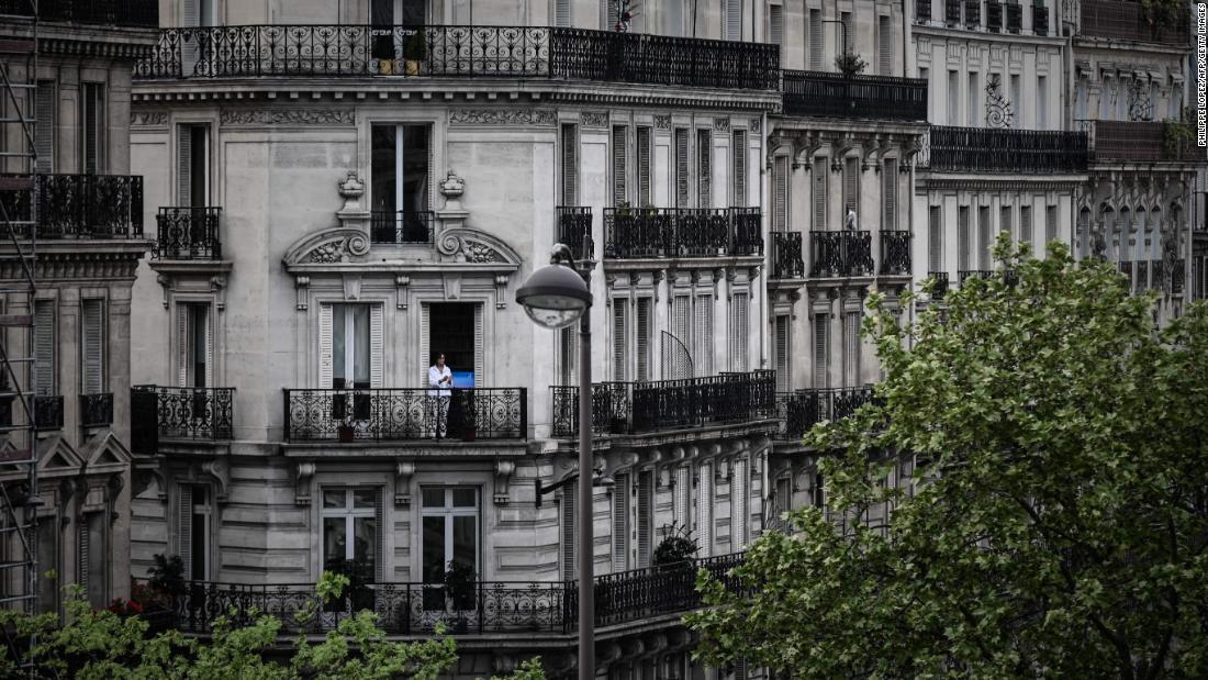 A woman applauds from the balcony of her Paris home to show support for health care workers on April 20, 2020.