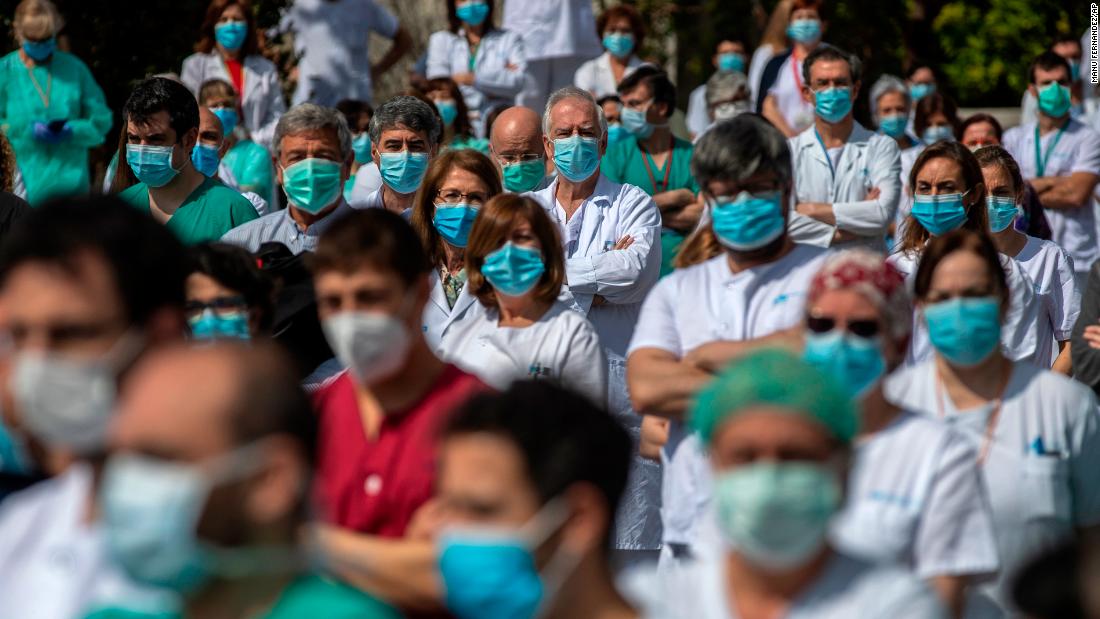 Health workers at Madrid's La Paz Hospital hold a minute of silence to remember Joaquin Diaz, the hospital's chief of surgery who died because of the coronavirus.
